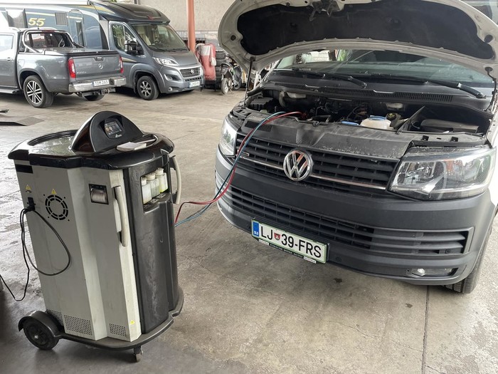 Naprava za polnjenje klime priklopljena na kombi pred delavnico GP Skok
